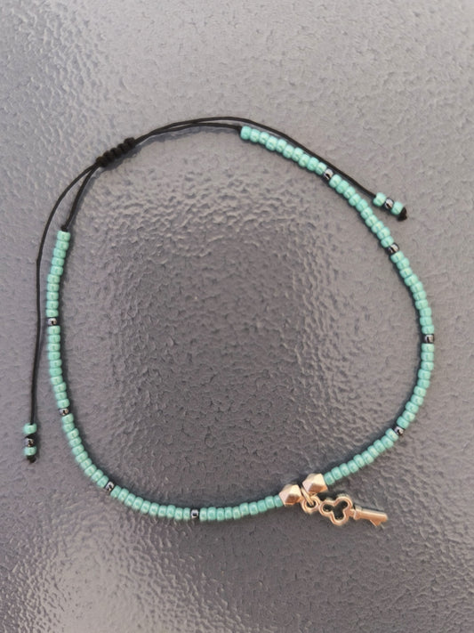 Bratara de picior reglabila cu Toho albastru si hematit, charm cheita – snur negru