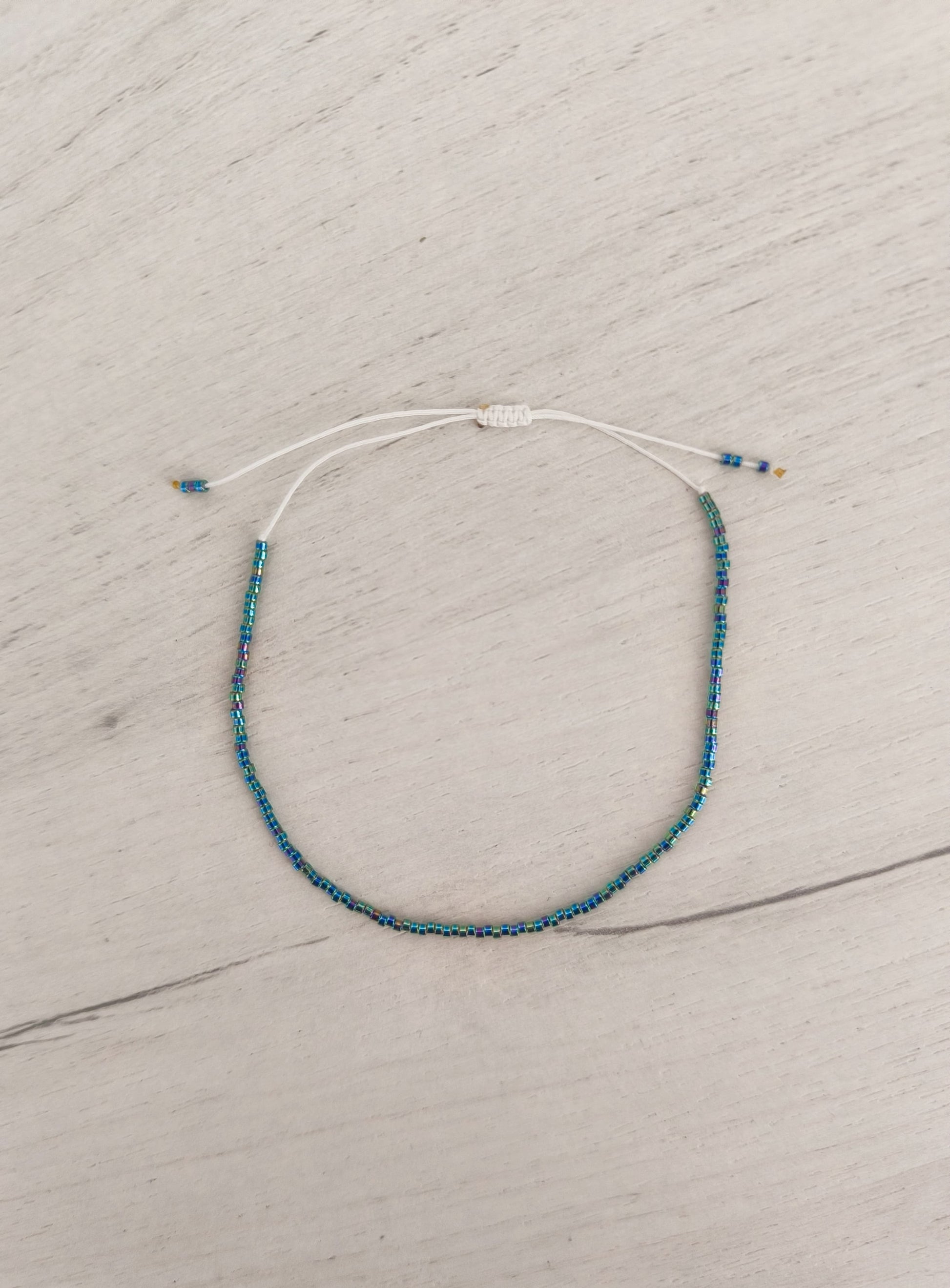 Bratara de picior reglabila cu Miyuki curcubeu metalic – snur alb