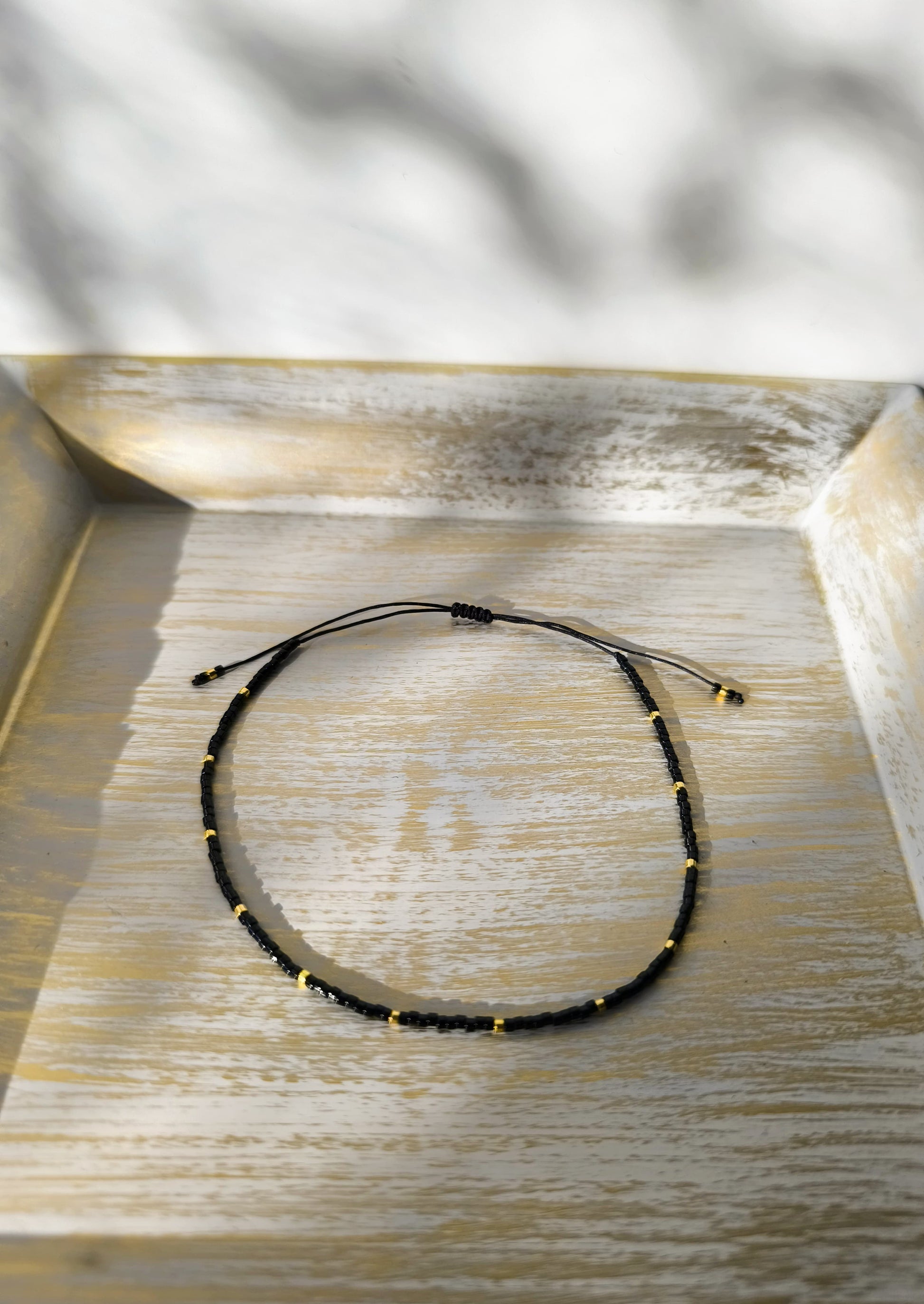 Bratara de picior reglabila cu Miyuki negru si auriu – snur negru