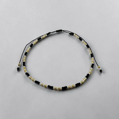 Bratara de picior reglabila cu margele negru mat, alb mat si auriu - snur negru